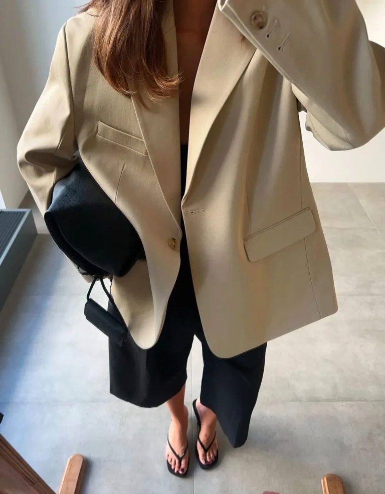 Minimalist spring outfit featuring oversized beige blazer with black pants and flats