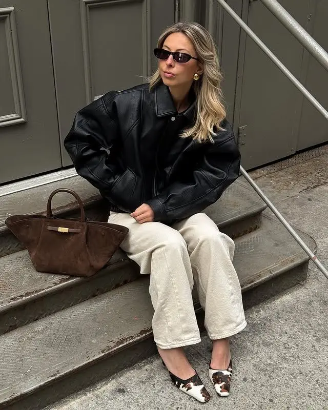 Minimalist spring outfit with black leather jacket and cream wide-leg pants