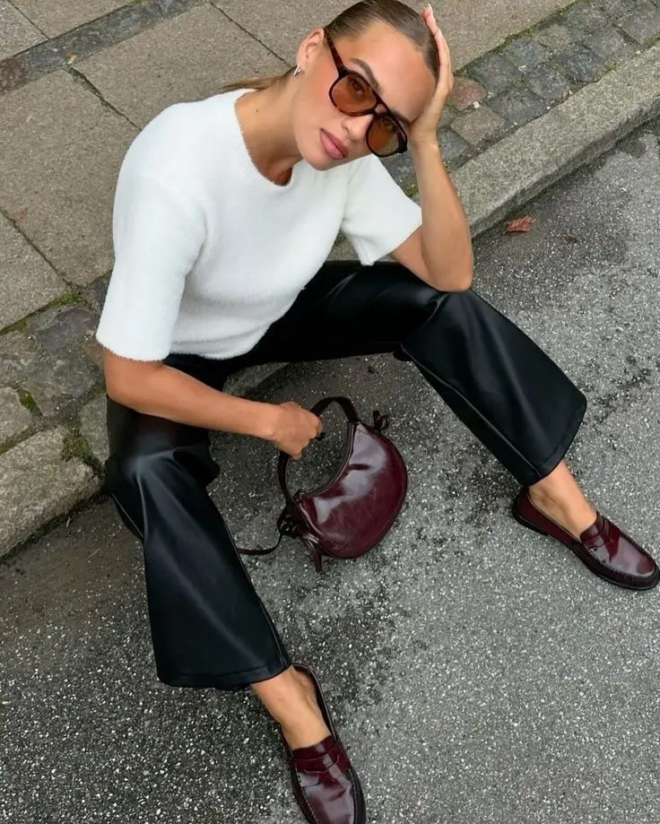Textured spring minimalist outfit idea with white sweater and leather pants