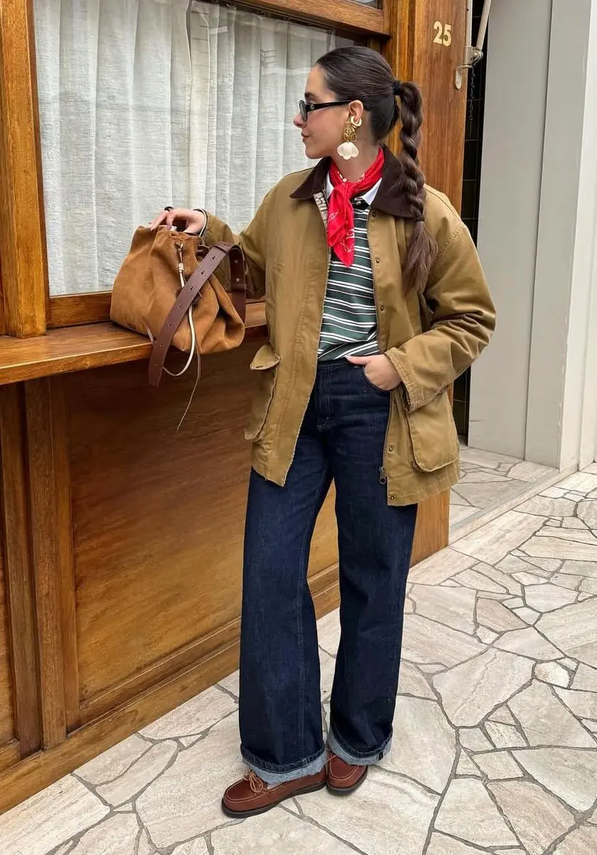 Woman wearing tan barn jacket with brown corduroy collar over striped tee and wide-leg jeans for spring outfit ideas
