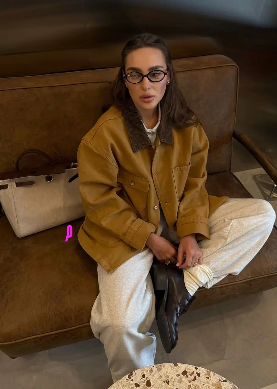 Mustard barn jacket styled with cream sweatpants and brown loafers for comfortable spring outfit