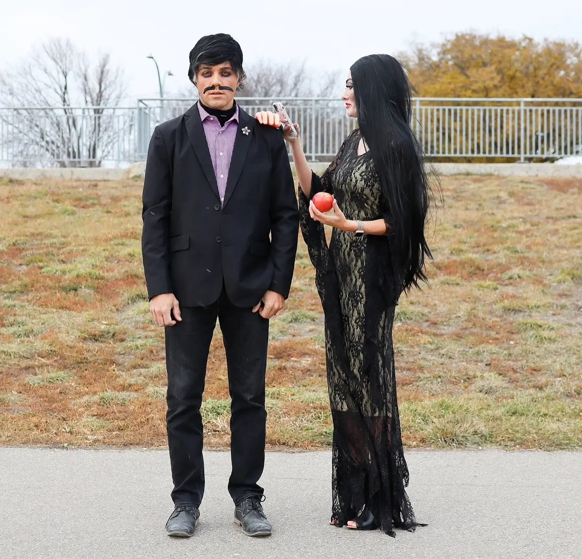 Man in black suit with mustache and woman in black lace gown as Gomez and Morticia Addams costume 10