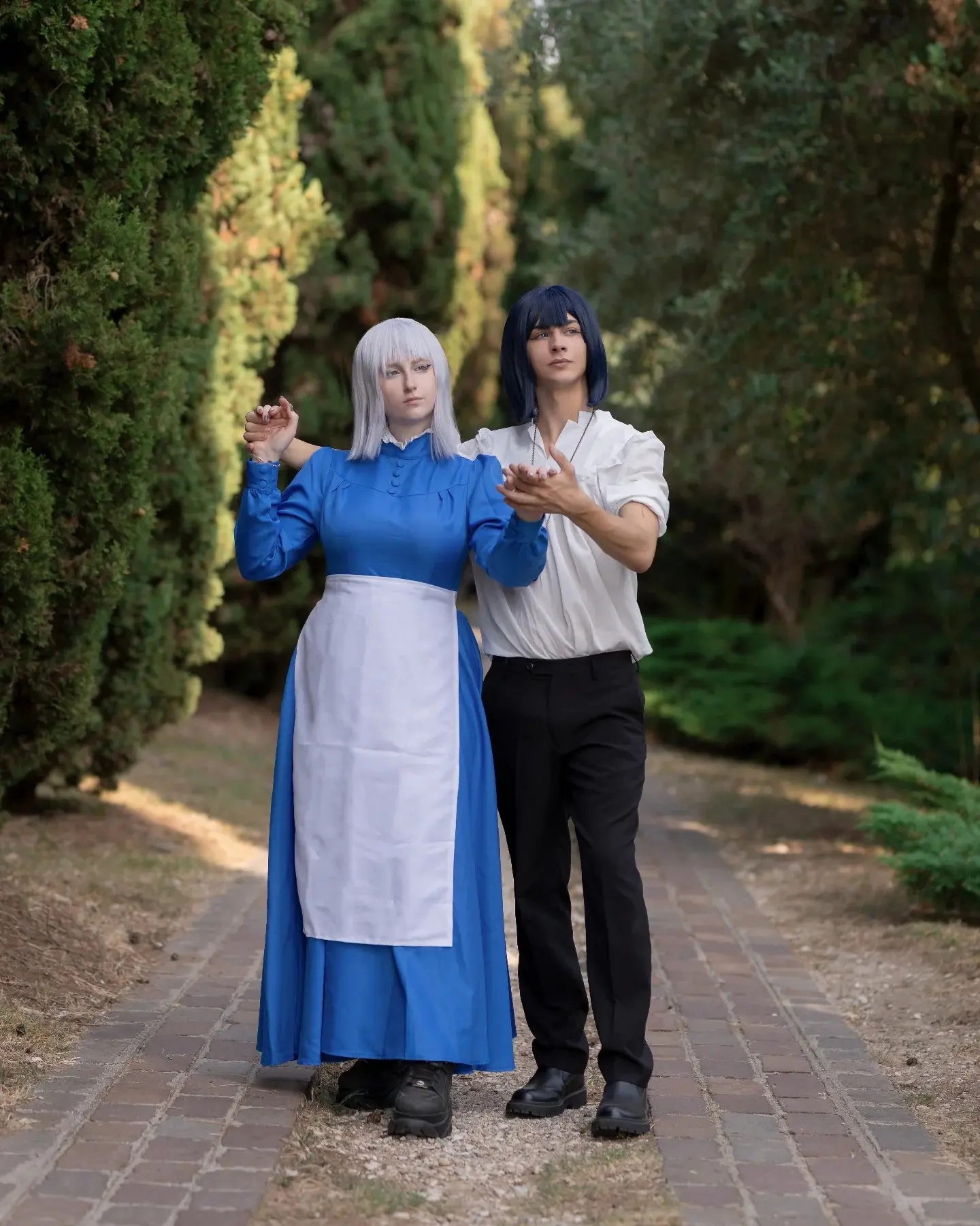 Couple in blue dress and white shirt with blonde and black wigs as Howl's Moving Castle characters costume 2