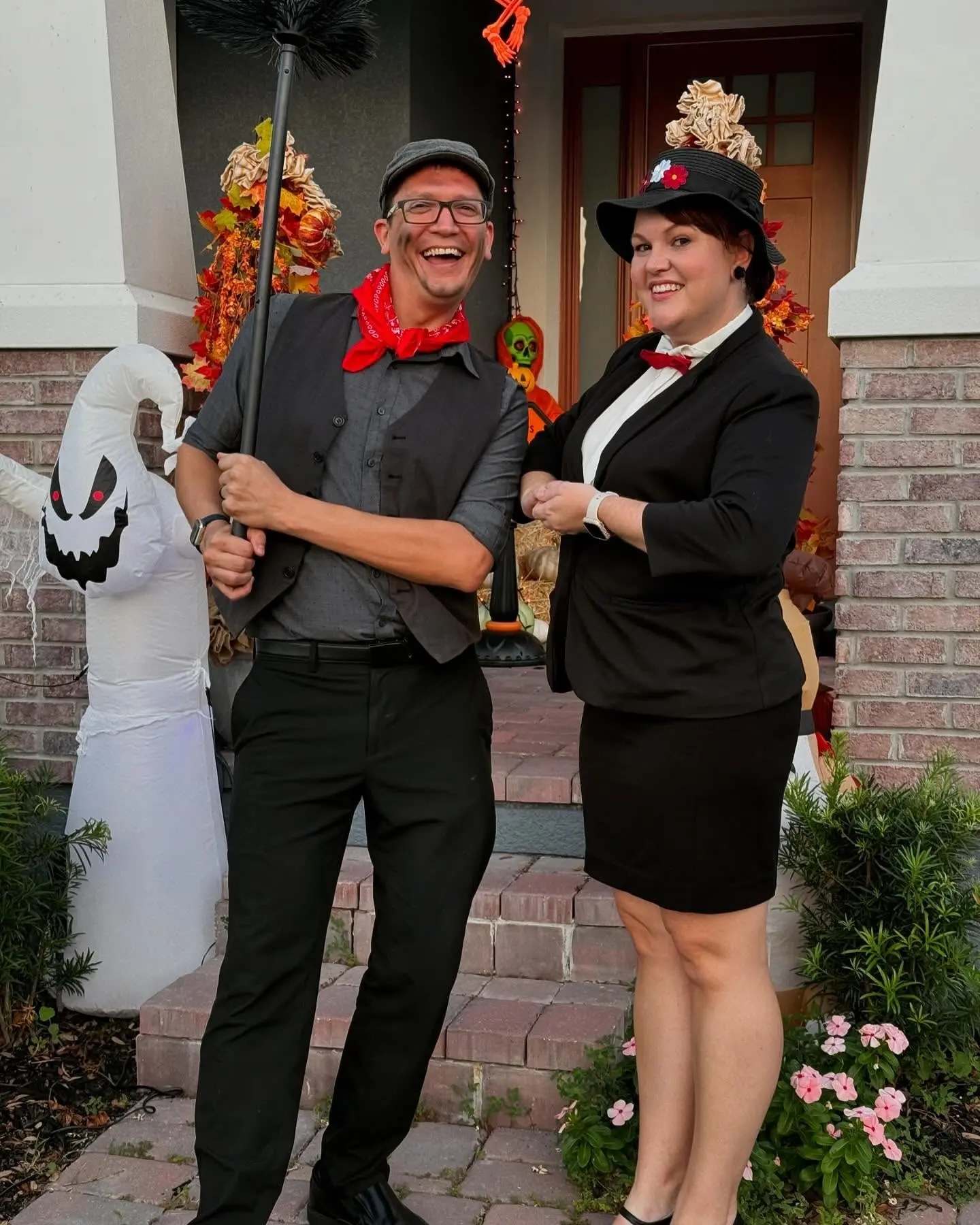 Man in gray vest and cap with soot marks as chimney sweep, woman in black dress and hat as Mary Poppins costume 1