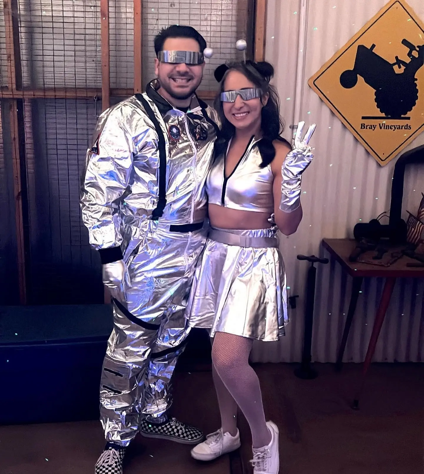 Couple in metallic silver jumpsuits and reflective sunglasses as retro astronauts costume 9