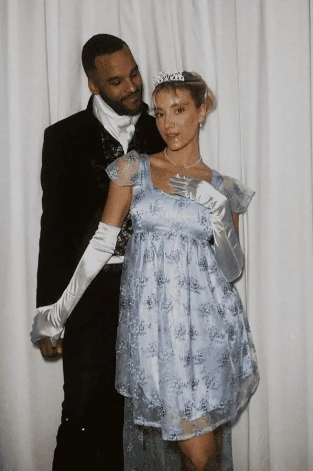 man in black formal suit with white cravat standing next to woman in light blue empire waist dress with white gloves and tiara outfit 2