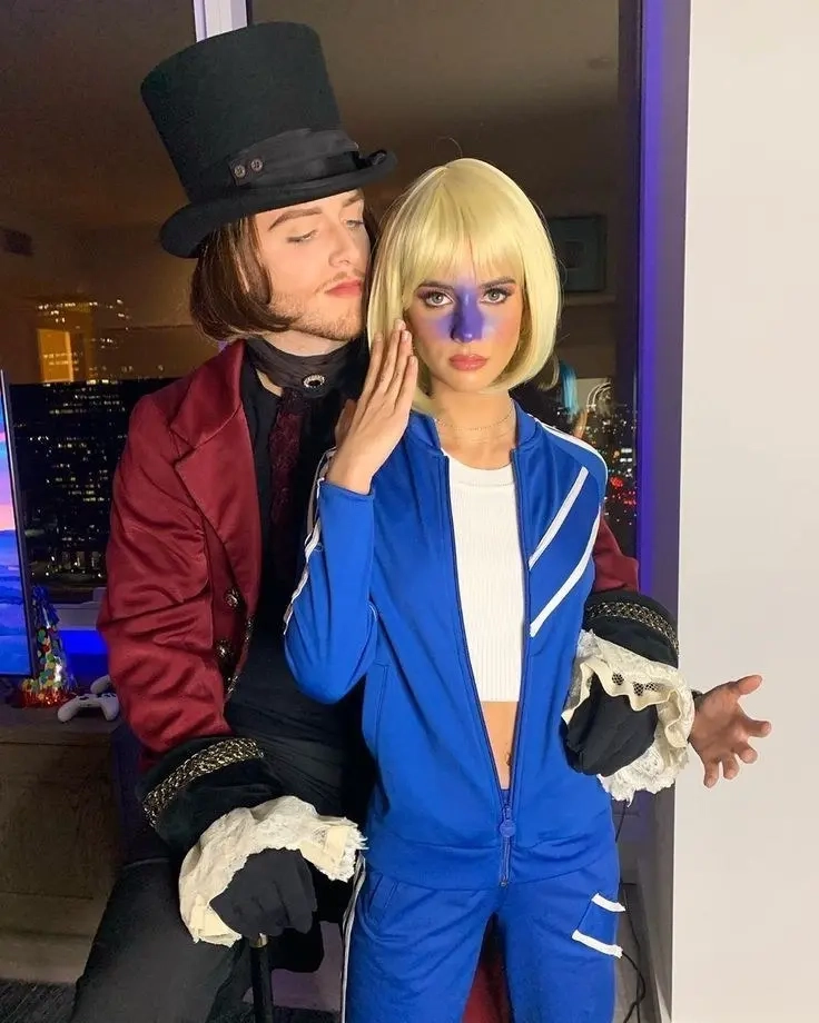 man in burgundy coat with top hat next to woman in blue tracksuit with blonde bob wig outfit 5