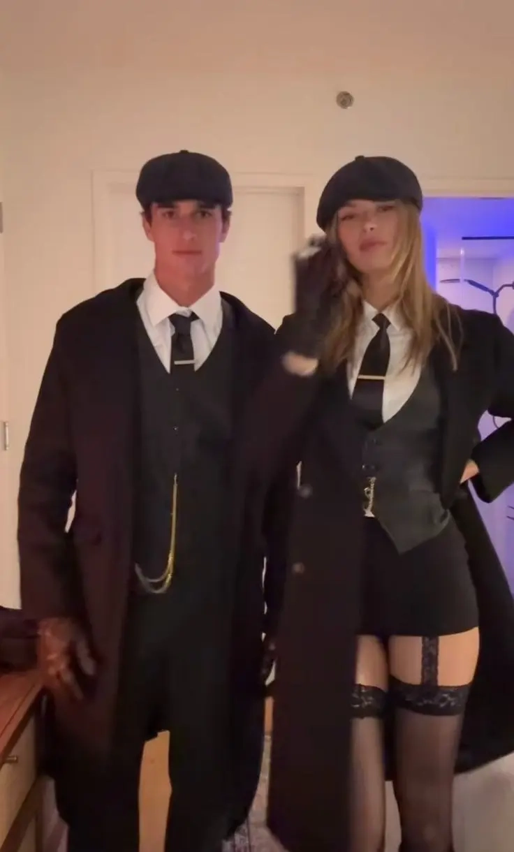 man and woman both in black suits with newsboy caps and vintage styling outfit 14