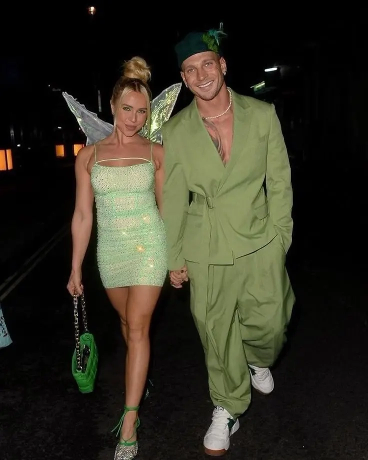 woman in sparkly green dress with fairy wings next to man in green tunic and feathered hat outfit 17