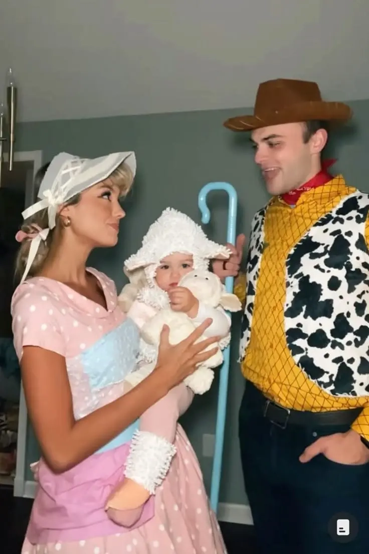 woman in bo peep costume with pink dress white bonnet, man in woody costume with yellow vest cowboy hat, baby in white sheep costume toy story family outfits 2