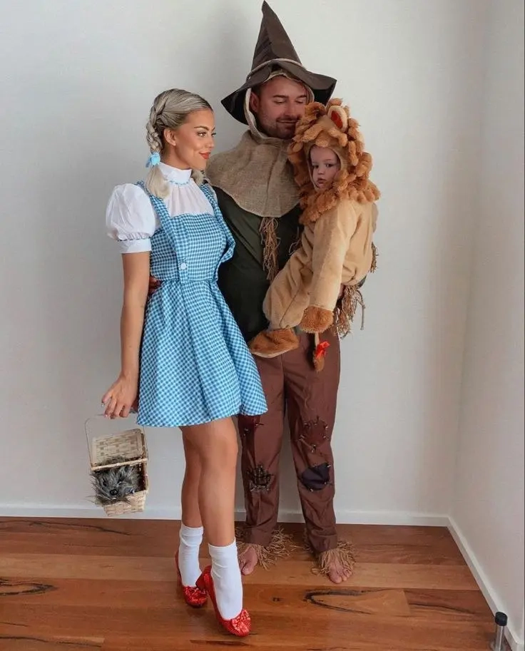 woman in dorothy costume blue gingham dress white blouse, man in scarecrow costume brown hat patched clothes, child in lion costume wizard of oz family outfits 3