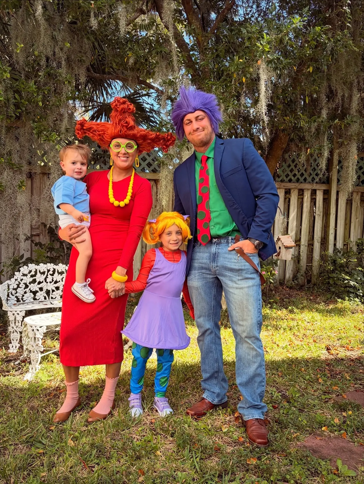 family in rugrats costumes with colorful wigs, red dress yellow dress purple dress, man in suit rugrats characters family outfits 9