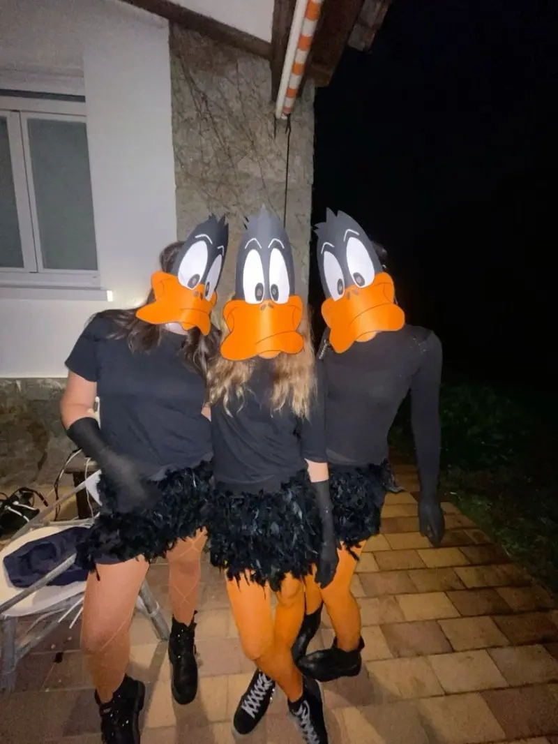 three women in black outfits with orange daffy duck bills and character accessories outfit 13