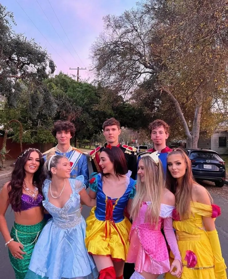 group of young people in disney character costumes including princesses and princes posing outdoors outfit 4