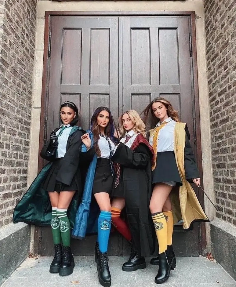 four women in hogwarts house uniforms with robes ties and house colors by brick wall outfit 15