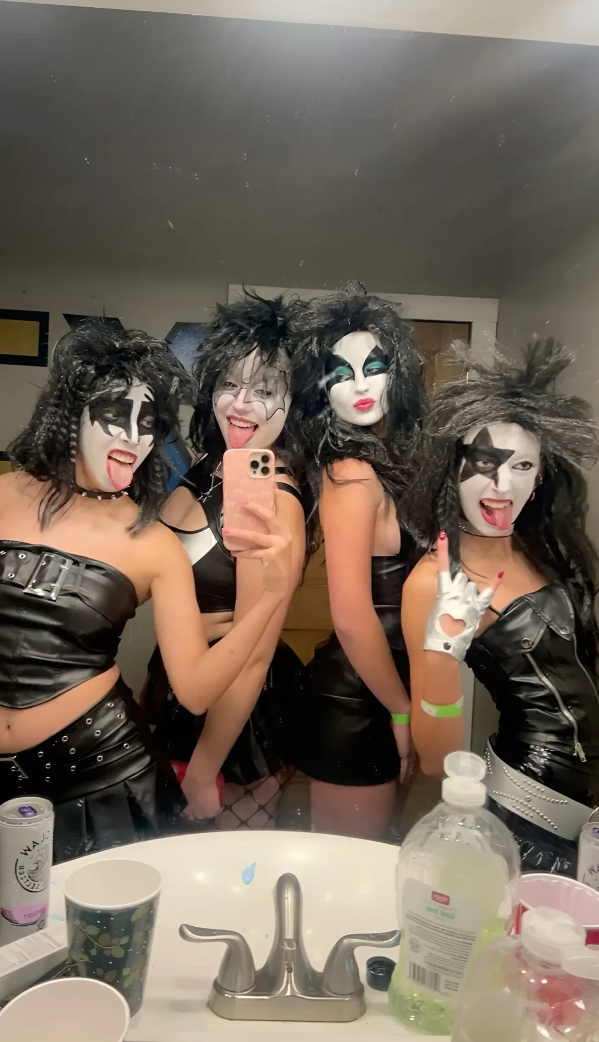 group of women in kiss band costumes black leather outfits dramatic face paint 11