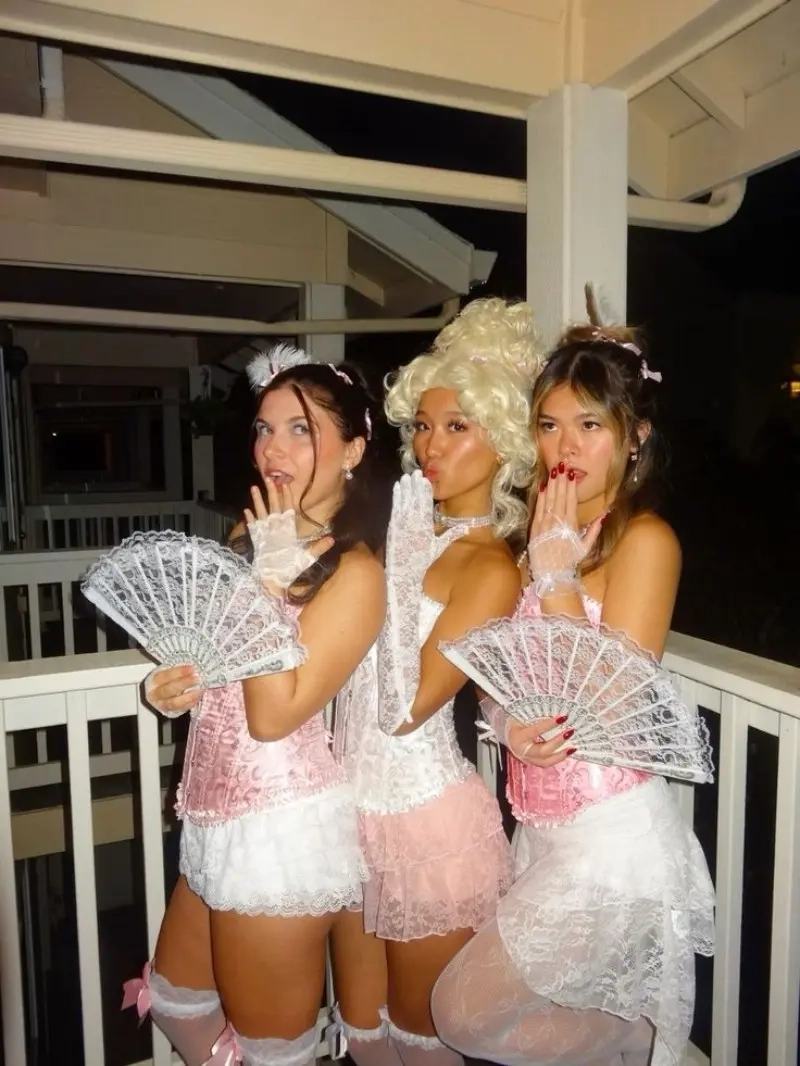 three women in marie antoinette costumes white corsets fans powdered wigs 7