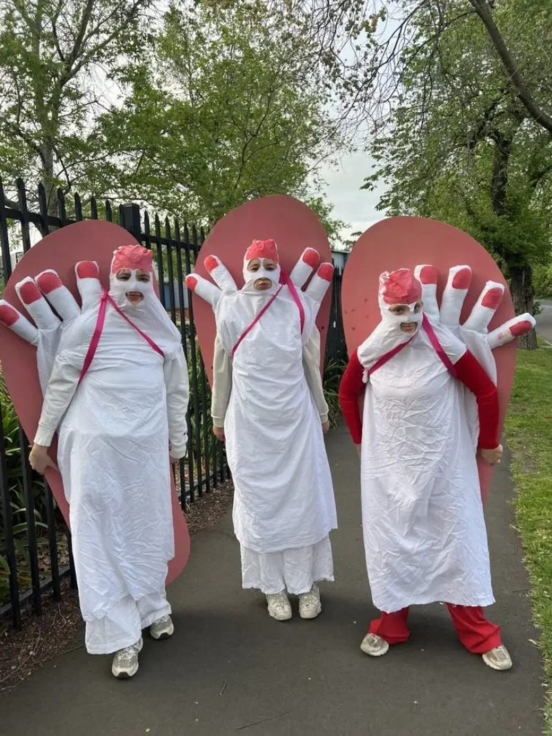 three women in white maxi pad costumes with red details wings 8
