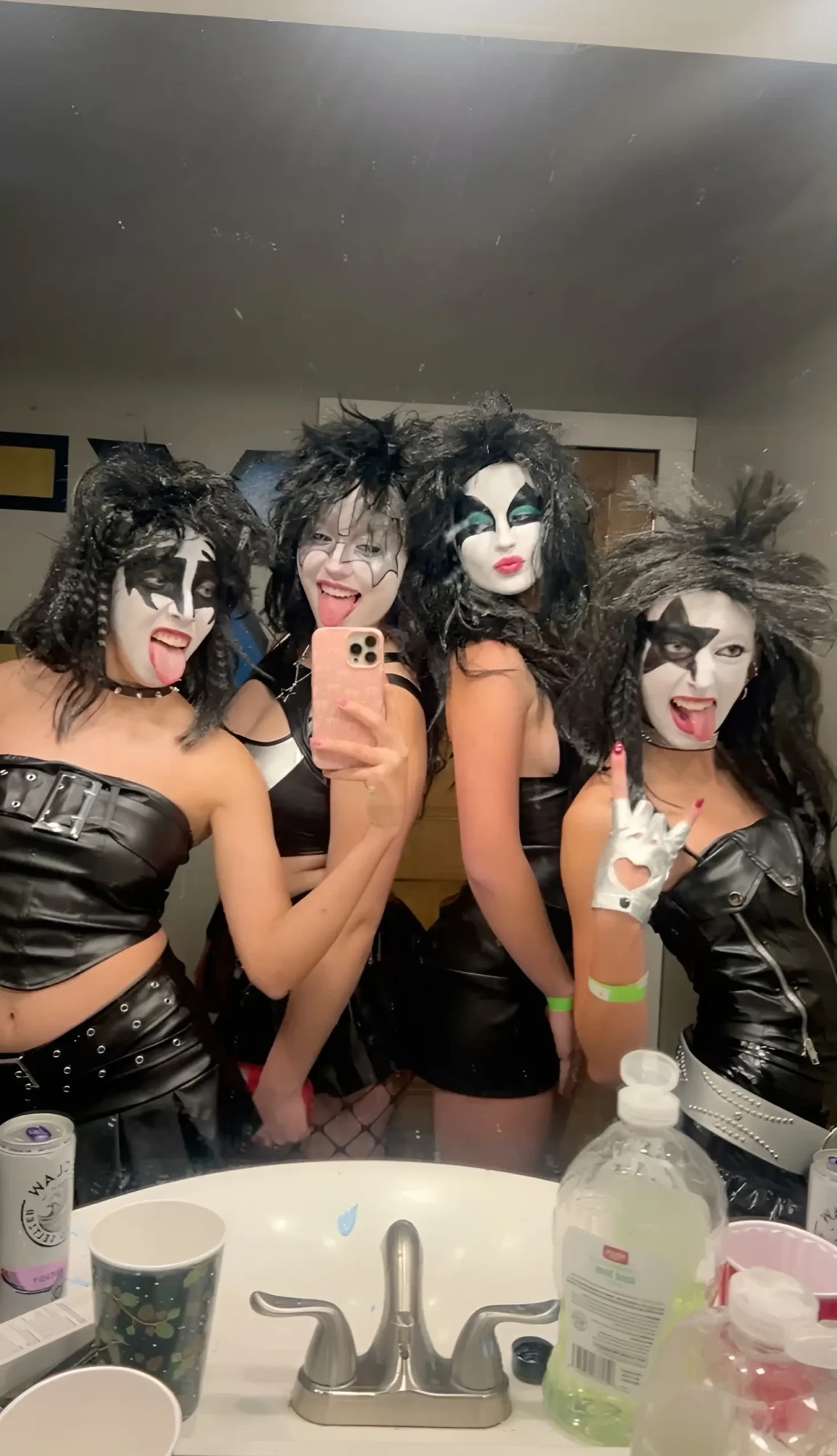 group of women in kiss band costumes black leather outfits dramatic face paint 11