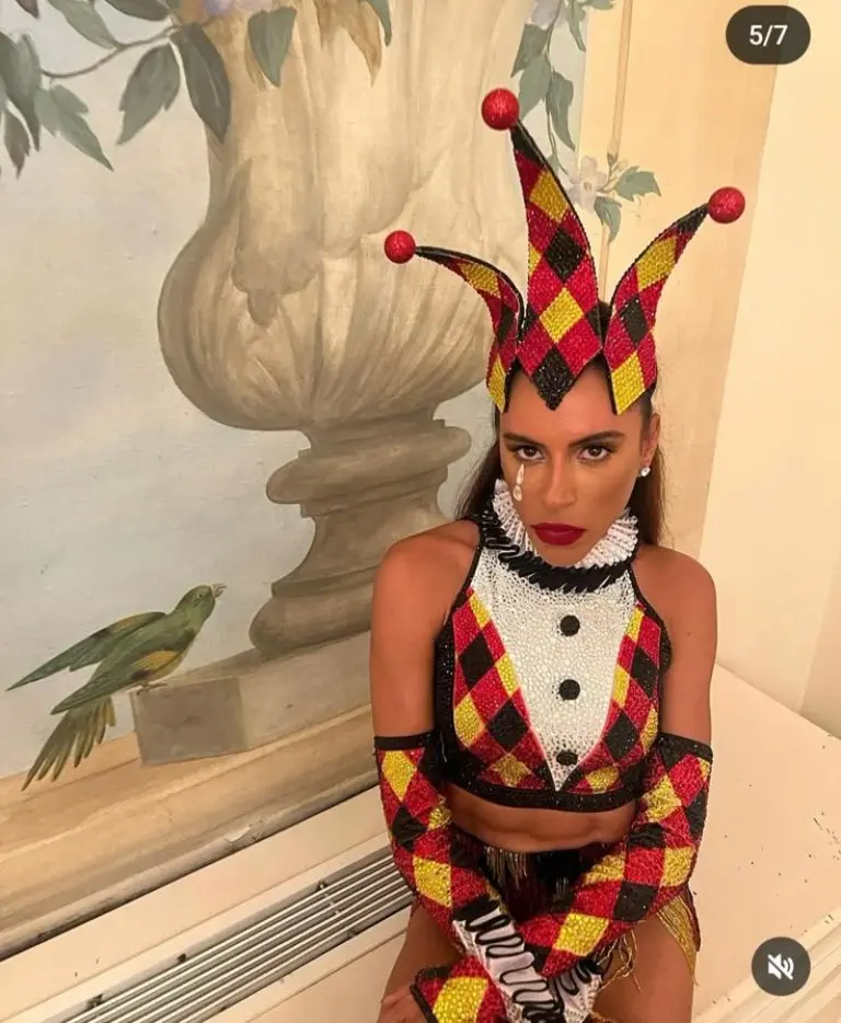 woman in red black gold diamond pattern harlequin jester costume with pointed hat and collar 1
