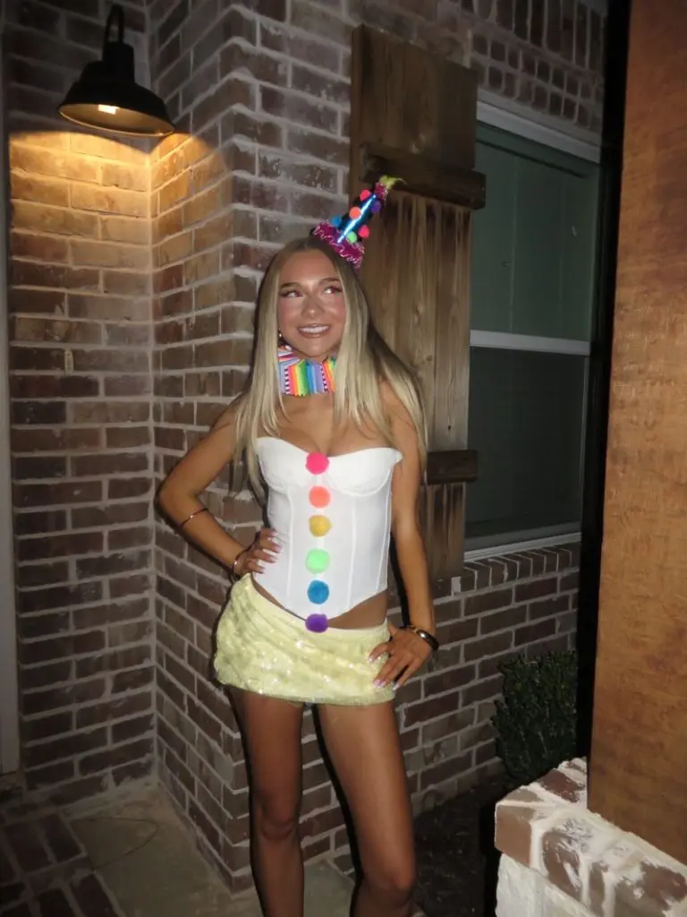 woman in white corset with rainbow pom poms lime green skirt and colorful party hat 4