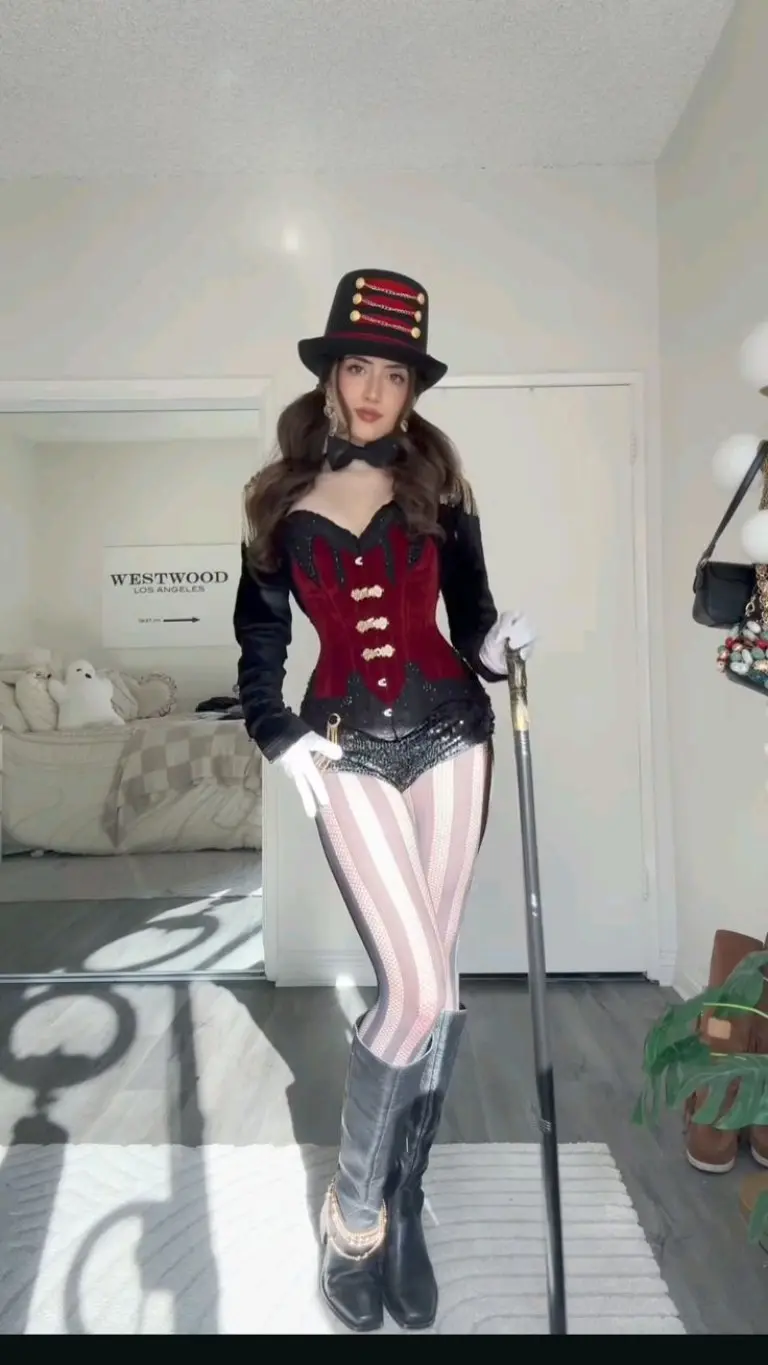 woman in red velvet military style ringmaster costume with black top hat and striped tights 5
