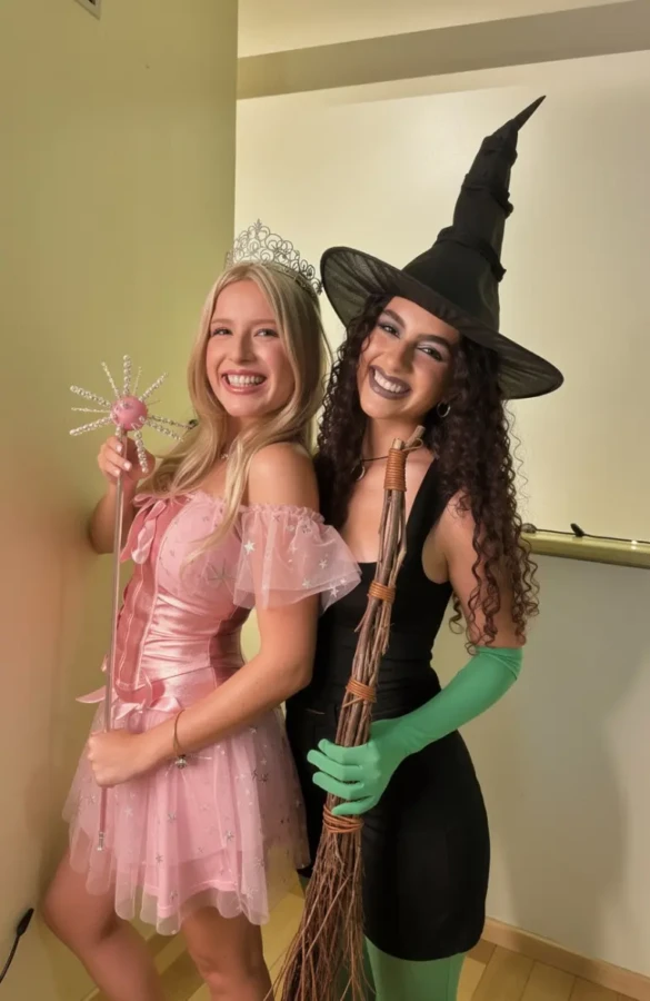 two women as good witch in pink dress and wicked witch in black with hat outfit 2