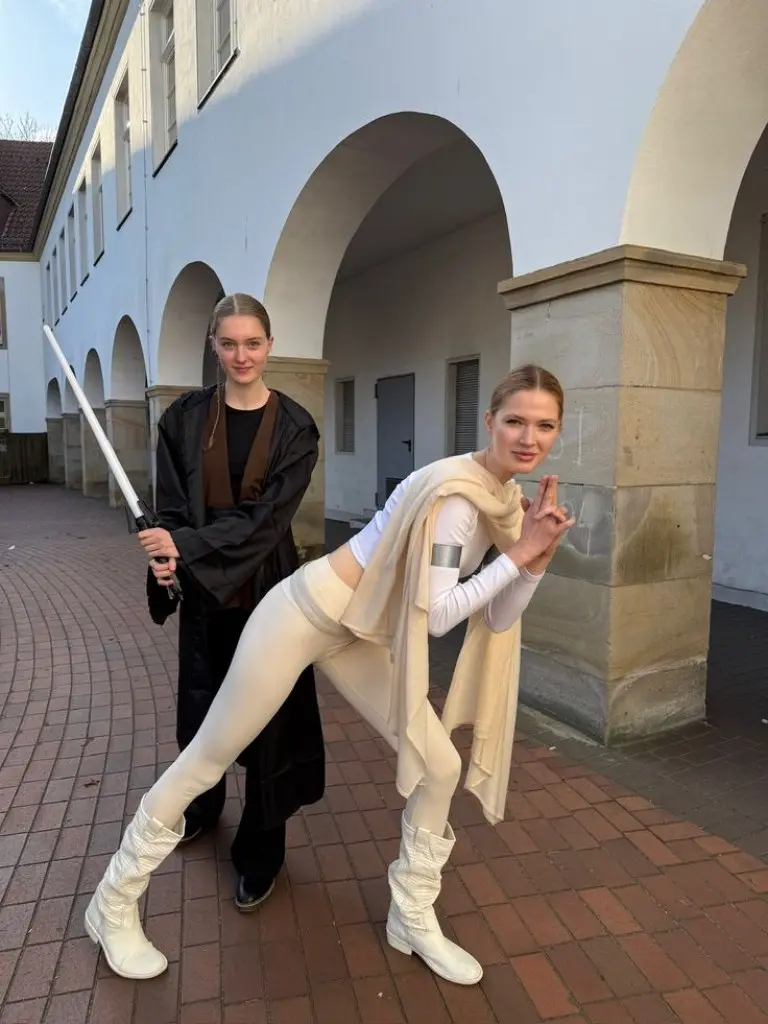two women in Star Wars costumes as Jedi and Sith with lightsabers outfit 9