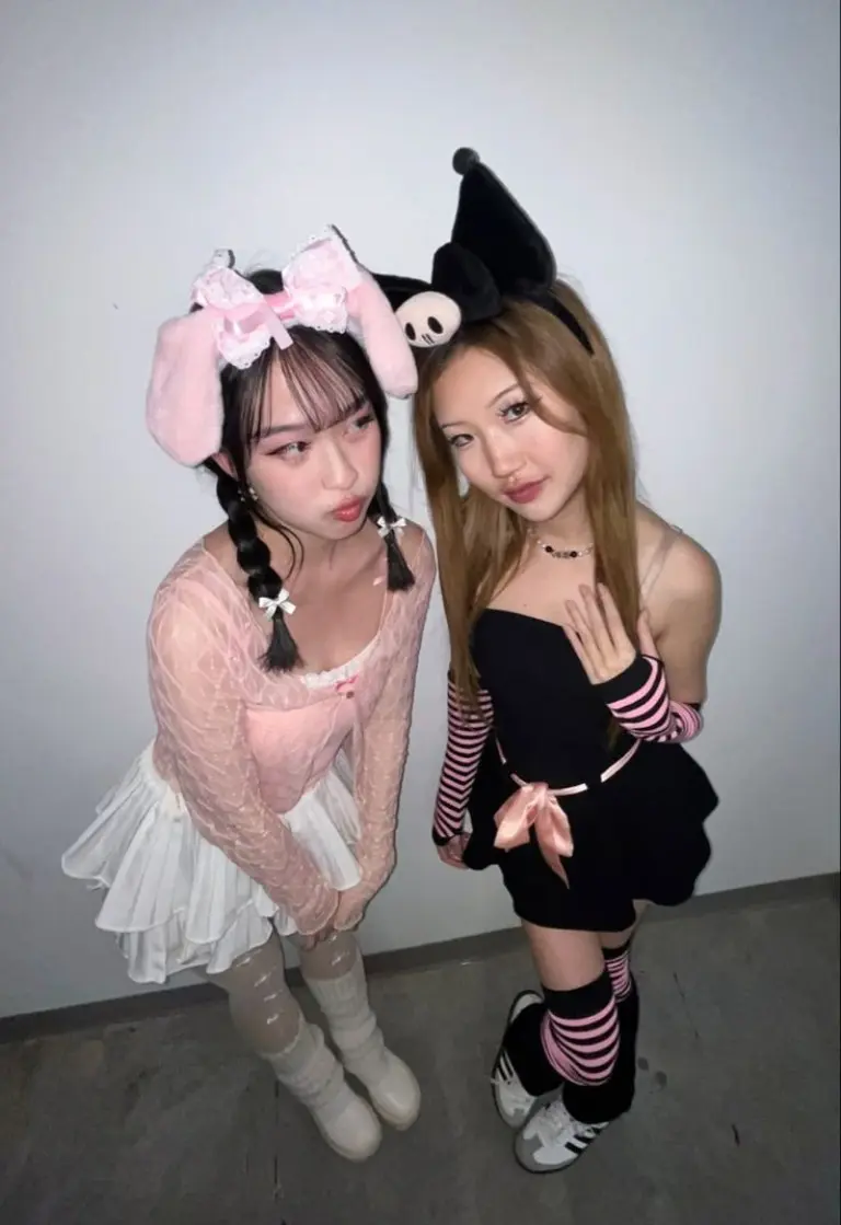 two women as Y2K style angel in pink and witch in black striped outfit 11