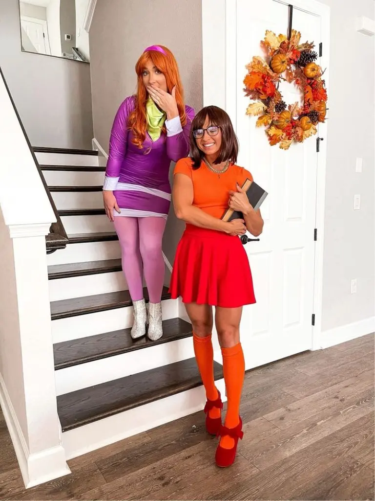 two women as Daphne and Velma from Scooby Doo in purple and orange outfits outfit 13