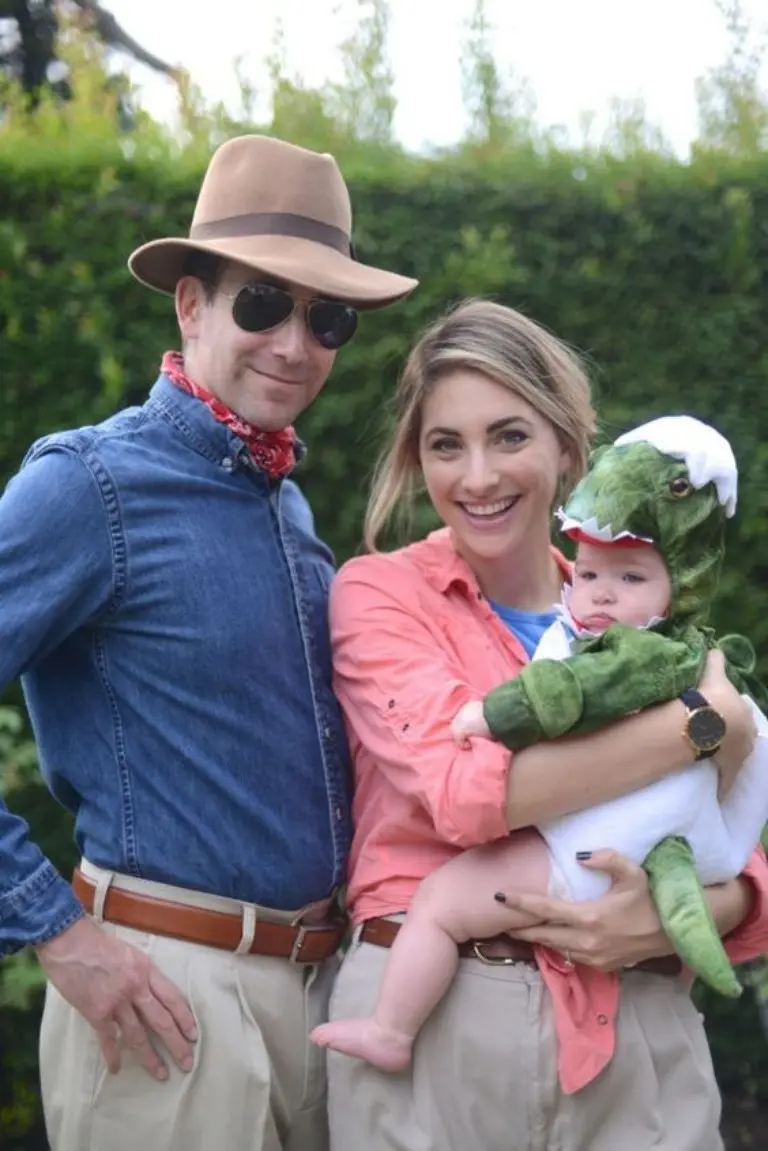 family in jurassic park explorer costumes khaki shirts hats sunglasses baby in green dinosaur costume 9