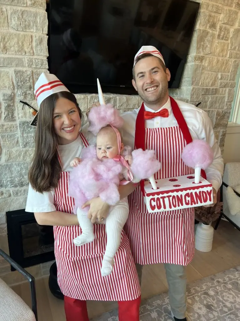 family dressed as cotton candy vendors in striped aprons and hats baby in pink fluffy cotton candy costume 16