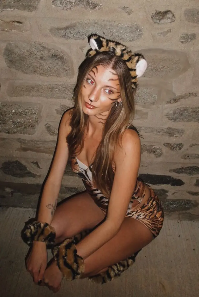 woman in tiger print bodysuit with tiger ears and face paint sitting outfit 7