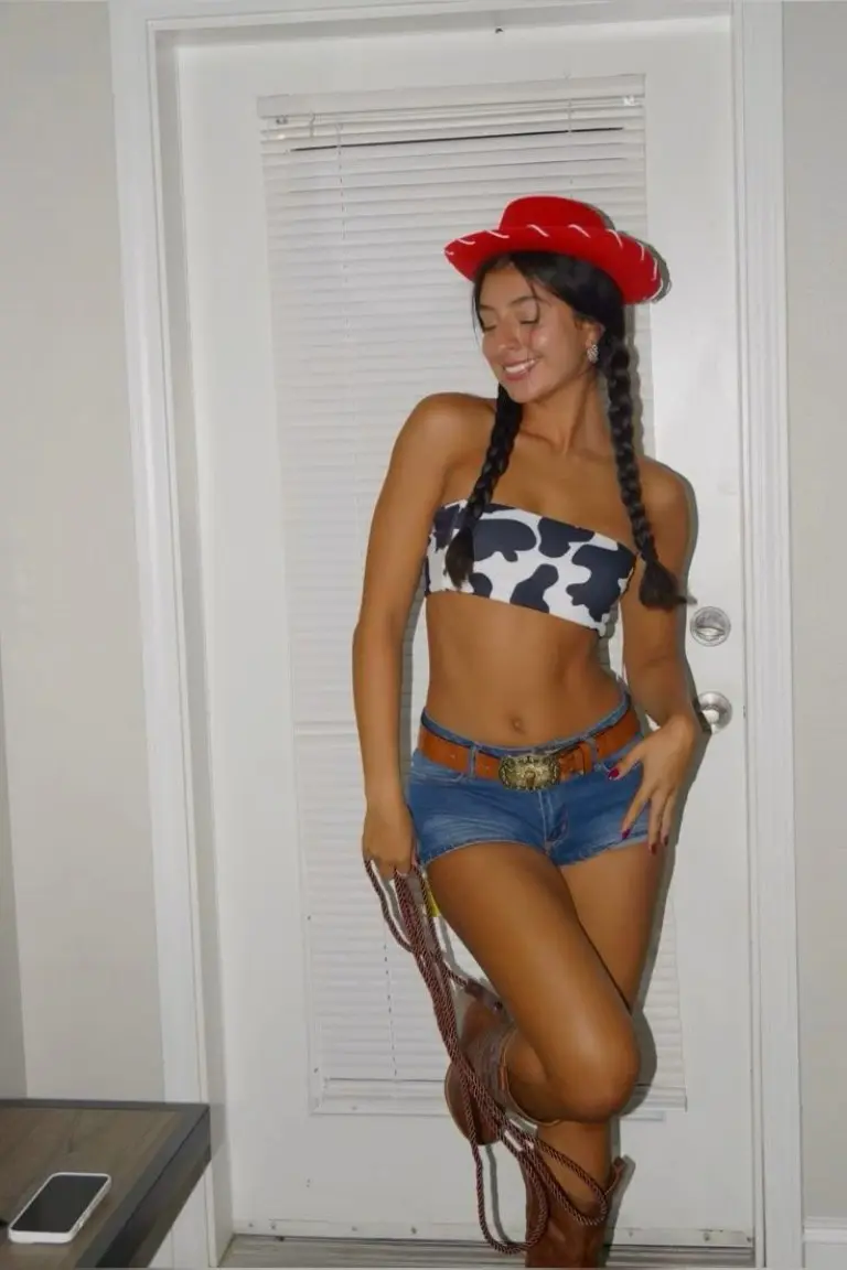 woman in cow print bandeau top denim shorts with red cowboy hat and braids outfit 12
