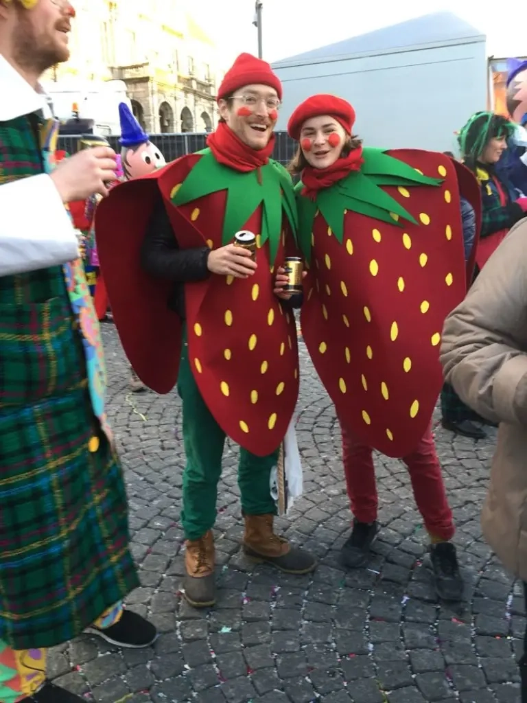 man woman in red green elf costumes with pointed hats and festive accessories outfit 14