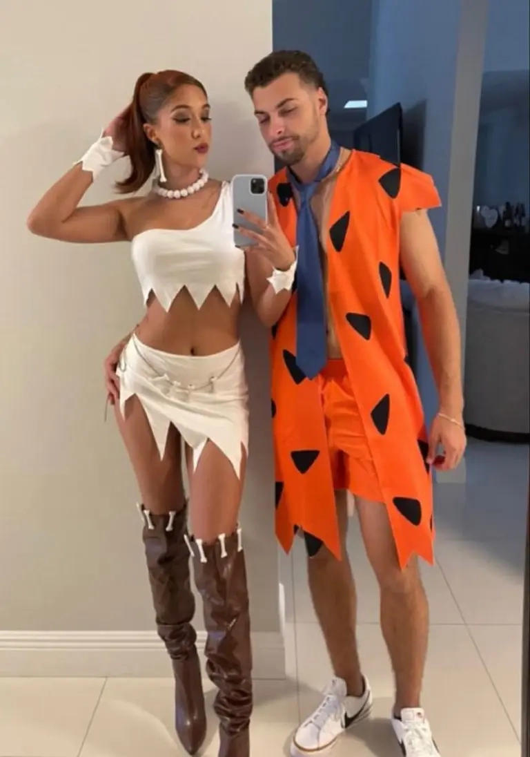 woman in white caveman dress pearl necklace man in orange spotted caveman outfit tie outfit 9