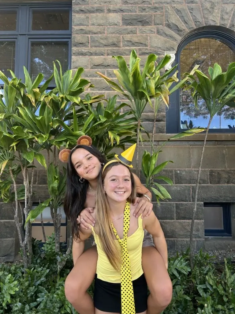 two teenage girls wearing mickey mouse inspired costume with yellow tie and character ears outfit 2