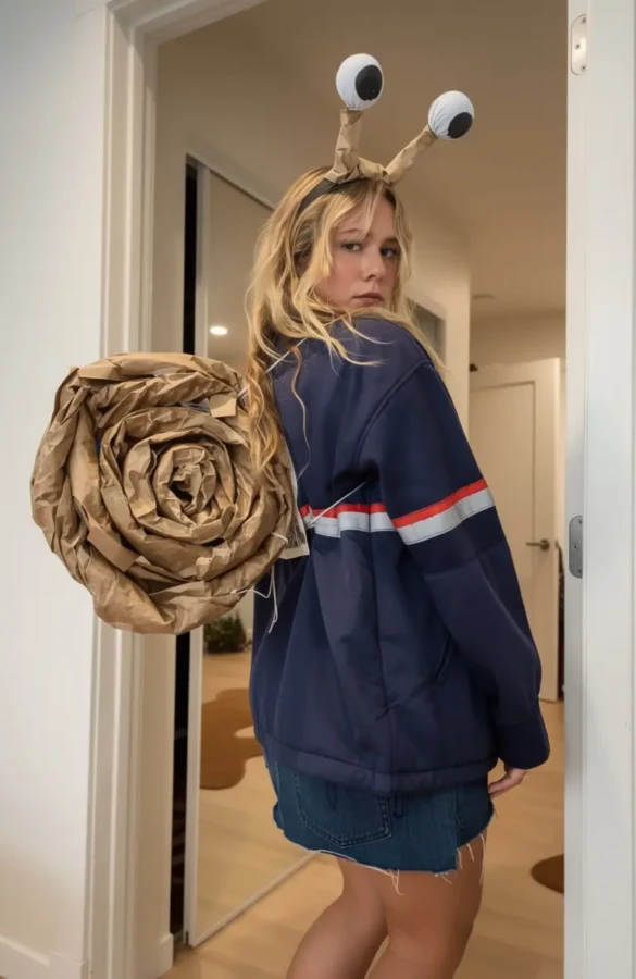 woman wearing navy sweatshirt with large brown snail shell prop and antennae headband outfit 2