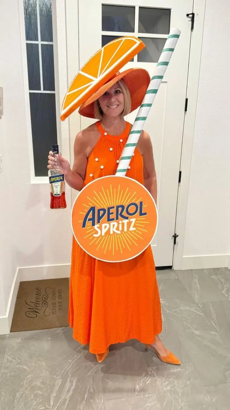 woman wearing orange dress with aperol spritz sign and orange hat holding bottle costume outfit 8