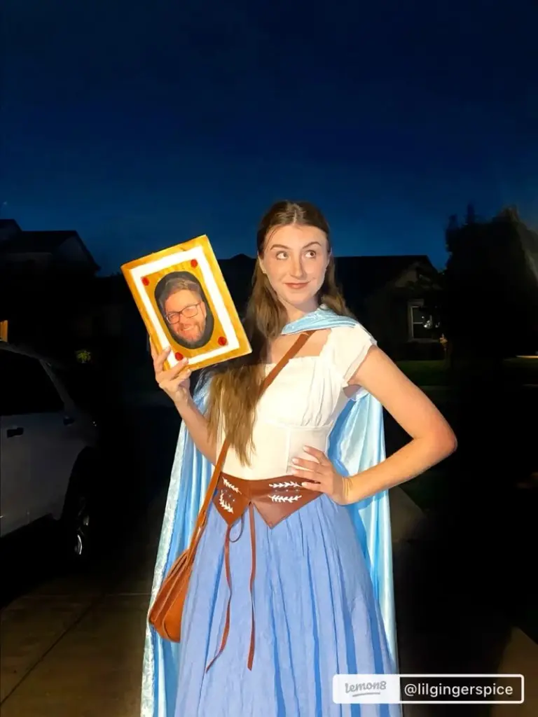 woman wearing blue and white classical dress holding picture frame art painting costume outfit 9
