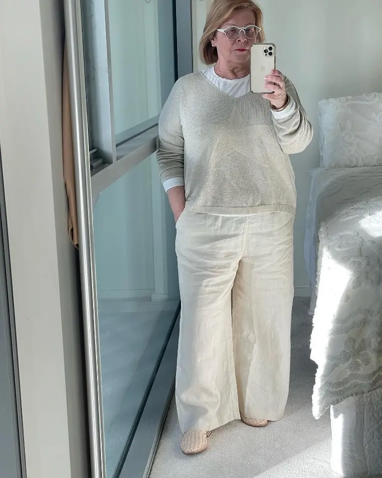 woman in beige knit sweater white shirt beige wide leg pants neutral flats phone mirror selfie 19