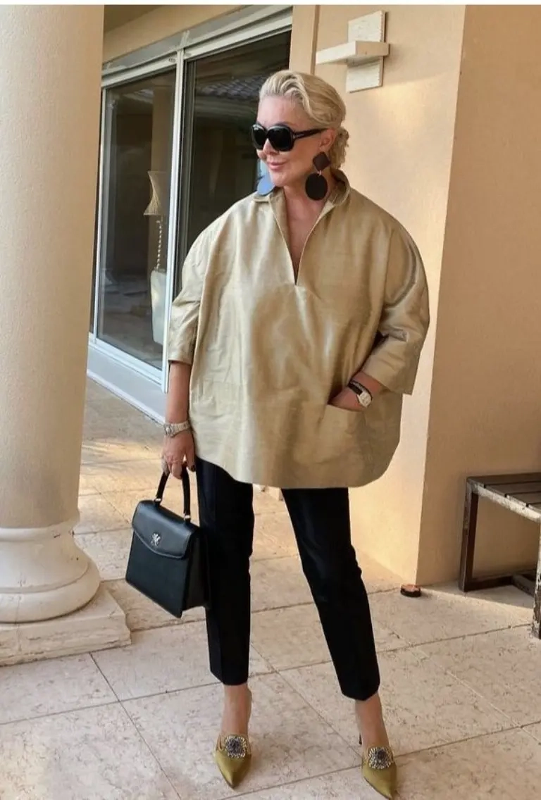 woman in beige oversized shirt black cropped pants sunglasses black structured bag gold pointed flats 4