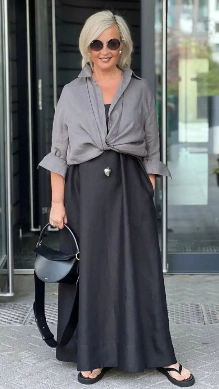 woman in grey knotted shirt over black maxi dress sunglasses structured bag sandals 9