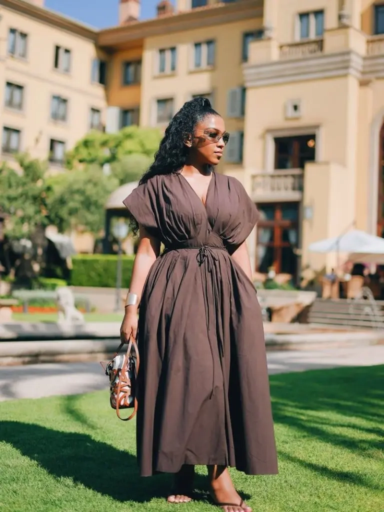 woman in brown kaftan style midi dress belted waist sunglasses patterned bag outfit 7
