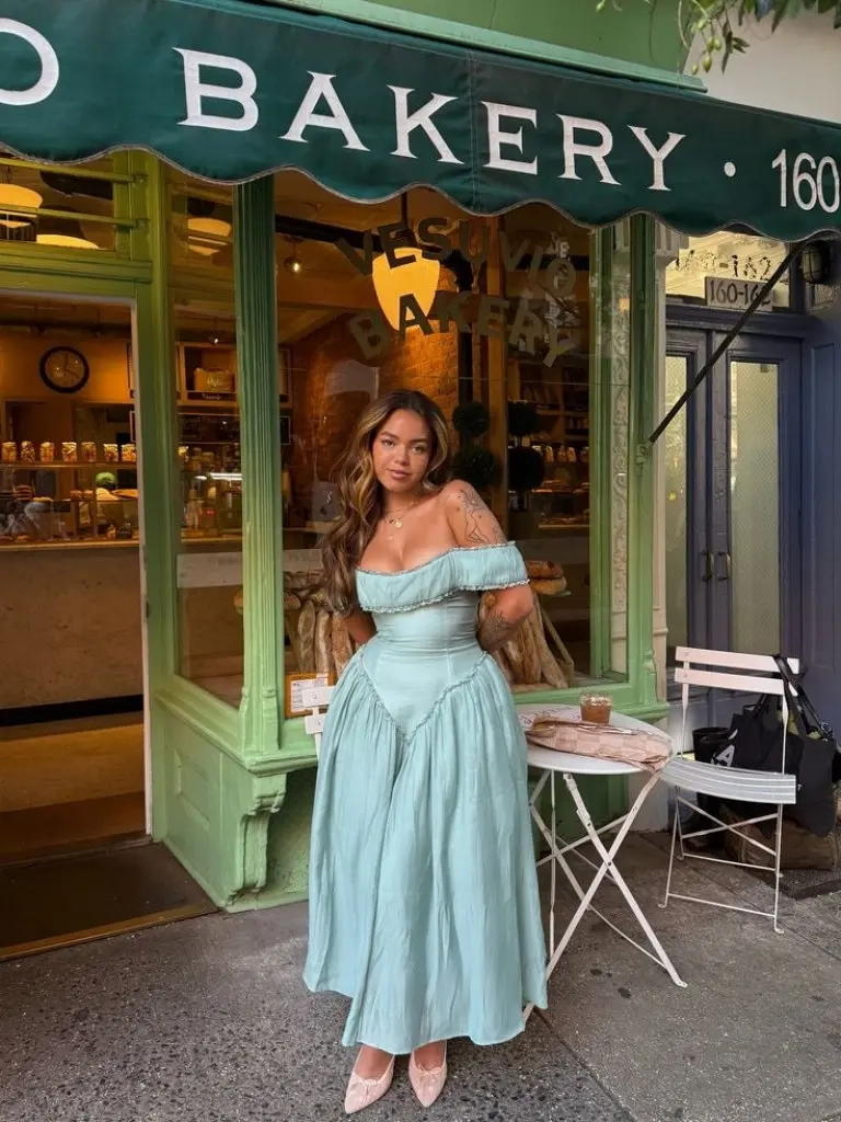 woman in mint green off shoulder midi dress nude pointed heels bakery background outfit 11
