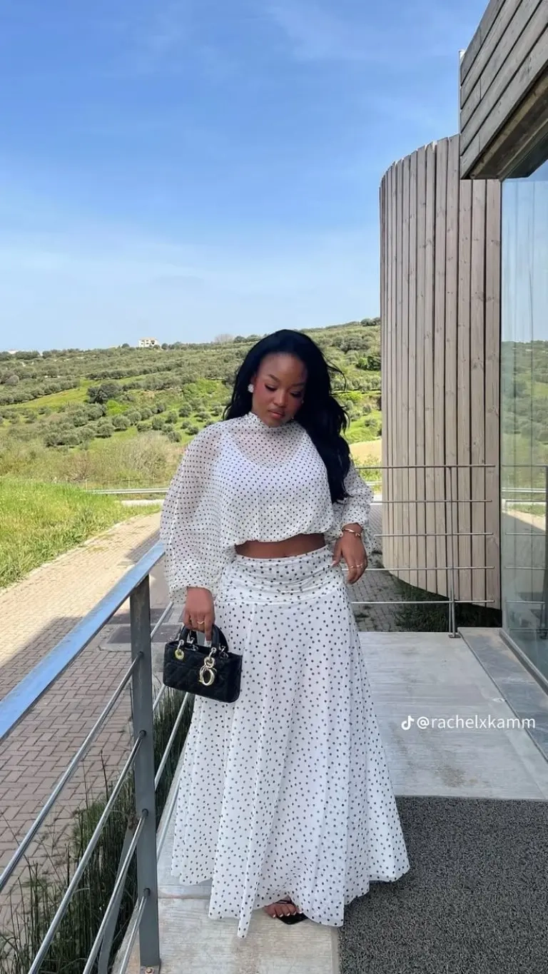 woman in white polka dot crop top matching maxi skirt black handbag outfit 5