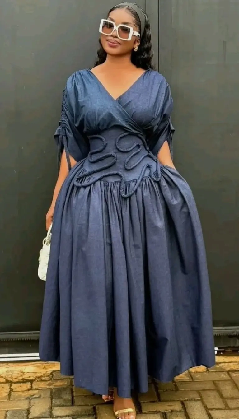 woman in blue chambray wrap dress with bow details white sunglasses white bag outfit 3