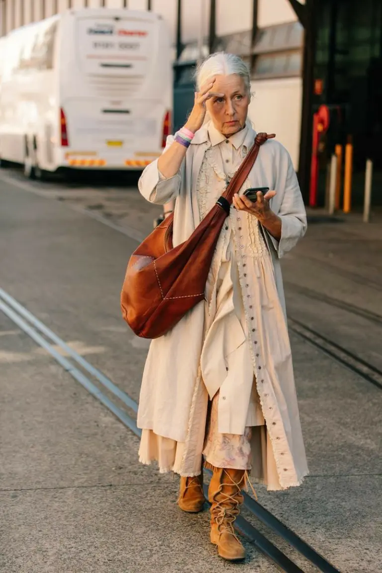 beige long coat cream dress cognac leather bag tan lace-up boots neutral layered outfit 3