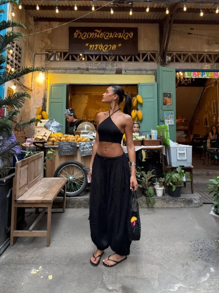 black halter crop top black wide leg pants flip flops mesh bag street food night market outfit 27