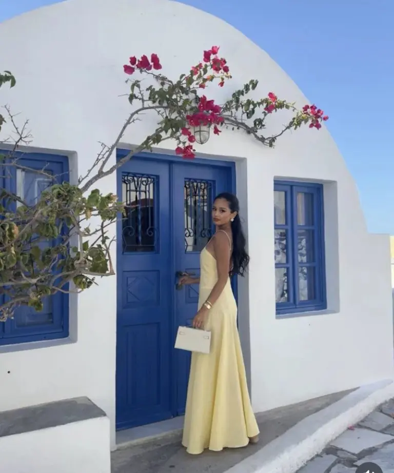 yellow sleeveless maxi dress with clutch against blue door and white walls outfit 7